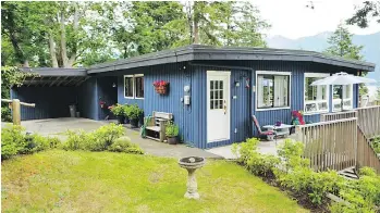  ??  ?? Built in 1974, the home at 1607 Old Eagle Cliff Rd. on Bowen Island has a deck that runs the width of the house.