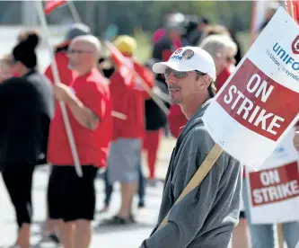  ?? BURCE CHESSELL/WOODSTOCK SENTINEL-REVIEW FILES ?? Striking workers walk the line outside the CAMI factory in Ingersoll, Ont., on Sept. 28. General Motors says it is considerin­g moving production of the Chevrolet Equinox from the plant as the strike go on.