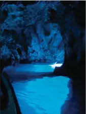  ??  ?? En entrant par une ouverture sous-marine, la lumière du soleil se transforme en une teinte bleu argenté qui vaut à cet endroit le nom de « grotte bleue ».
