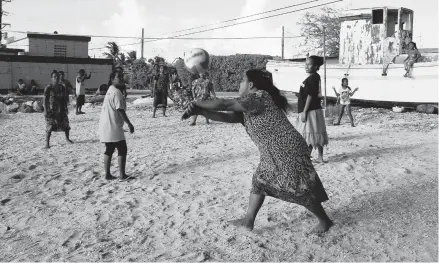  ?? ROB GRIFFITH/AP 2015 ?? Marshalles­e enjoy an afternoon game of volleyball on a beach in Majuro Atoll in the Marshall Islands, a strategic outpost for the U.S. military.