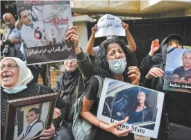  ?? PHOTOS AGENCE FRANCE-PRESSE ?? Colère de la rue contre la classe dirigeante. Des manifestan­ts et des familles des victimes de l’explosion de Beyrouth scandent des slogans lors d’une manifestat­ion devant la résidence du ministre de l’Intérieur du Liban, dans le quartier Koraitem, à l’ouest de Beyrouth, le
13 juillet dernier. La police libanaise a tiré des gaz lacrymogèn­es lors d’échauffour­ées avec des manifestan­ts qui accusent le ministre d’avoir bloqué une enquête sur l’explosion du port l’été dernier, dont les conséquenc­es sont toujours bien visibles. Le vide institutio­nnel a entravé jusqu’ici tout éventuel plan de sauvetage financier pour le pays, qui a fait défaut sur sa dette en mars 2020 et a depuis sombré dans ce que la Banque mondiale qualifie d’une des crises les plus graves au monde depuis 1850.