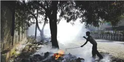  ??  ?? NEW DELHI: A young Indian rag picker is silhouette­d against smoke rising from the garbage burning on the roadside yesterday.—AP