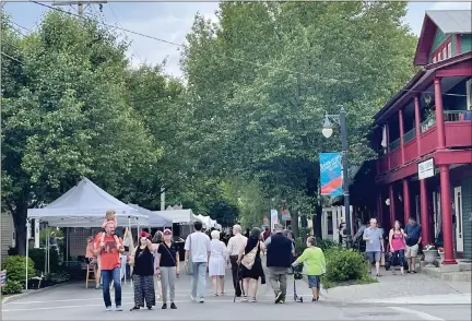  ?? PHOTO BY SKYE MASON ?? Eventgoers look through the various art stalls at the Beekman Street Art Fair in Saratoga Springs.