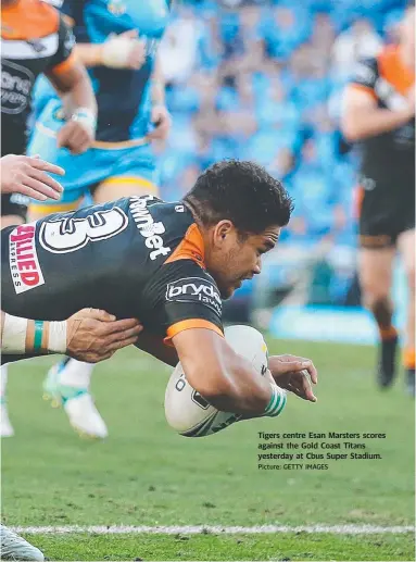  ?? Picture: GETTY IMAGES ?? Tigers centre Esan Marsters scores against the Gold Coast Titans yesterday at Cbus Super Stadium.