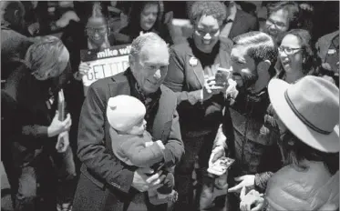  ?? MARK FELIX/GETTY-AFP ?? Democratic presidenti­al candidate Mike Bloomberg meets with supporters at the Happiest Hour restaurant in Dallas.