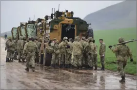  ??  ?? Turkish Army soldiers form a convoy of armoured personnel carriers near the border with Syria in the outskirts of Hassa, Turkey on Tuesday. Turkey’s Foreign Minister Mevlut Cavusoglu has announced that a second Turkish soldier has been killed in action...