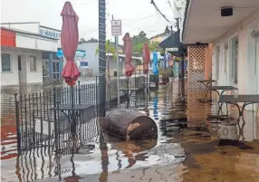  ?? PHOTOS BY IVY CEBALLO/TAMPA BAY TIMES VIA AP ?? Storm surge from Hurricane Idalia floods Athens Street in Tarpon Springs, Fla., on Wednesday.