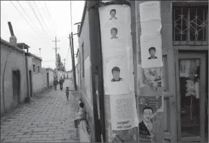  ?? The Associated Press ?? WANTED POSTERS: In this July 17, 2014, file photo, wanted posters of men involved in recent terror attacks are posted on a street of Aksu in western China’s Xinjiang province. Human Rights Watch said Tuesday that China appears to be laying the...