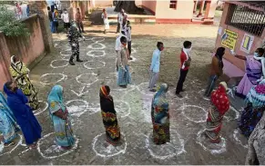  ?? — AP ?? Keeping their distance: Voters queuing in circle marked to maintain social distancing at a polling station during the first phase of state elections at Paliganj, Bihar.