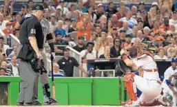  ?? MIKE EHRMANN/GETTY IMAGES ?? A signature moment from the game, Yadier Molina of the St. Louis Cardinals takes a photograph of Nelson Cruz of the Seattle Mariners and umpire Joe West.