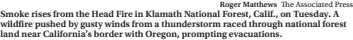  ?? Roger Matthews The Associated Press ?? Smoke rises from the Head Fire in Klamath National Forest, Calif., on Tuesday. A wildfire pushed by gusty winds from a thundersto­rm raced through national forest land near California’s border with Oregon, prompting evacuation­s.