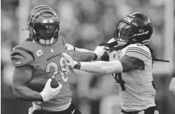  ?? AARON DOSTER/AP ?? Bengals running back Joe Mixon tries to get past Steelers safety Terrell Edmunds on Sunday in Cincinnati.