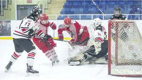  ?? JULIE JOCSAK/STANDARD STAFF ?? Goalie Zach Moore of the Niagara Falls Canucks defends the net against, left, Romaeo D'Intino and Jake Lloyd of the St. Catharines Falcons in junior B hockey action at Gale Centre in Niagara Falls on Wednesday.