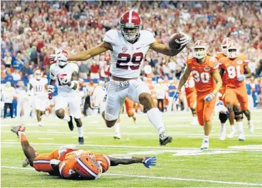  ?? KEVIN C. COX/GETTY IMAGES ?? Alabama’s Minkah Fitzpatric­k returns an intercepti­on for a touchdown, leaping over UF’s Brandon Powell.