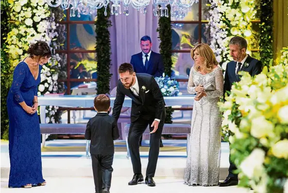  ??  ?? Happy moment: Lionel Messi welcoming his son Thiago as his parents Jorge Horacio Messi (right) and Celia Maria Cuccittini (second from right) and the bride’s mother Patricia Roccuzo (left) look on during the wedding ceremony. — AFP