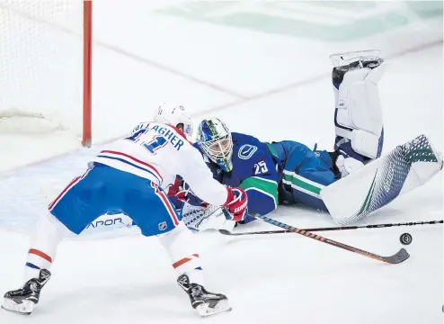  ?? — THE CANADIAN PRESS ?? Montreal’s Brendan Gallagher reaches for the puck in front of Vancouver goalie Jacob Markstrom during the second period of Saturday’s game at Rogers Arena. Solid defence from both sides made for few scoring chances.