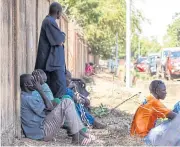  ??  ?? IN STATE OF SHOCK: Relatives of victims wait outside a morgue in Ouagadougo­u, Burkina Faso, on Friday.