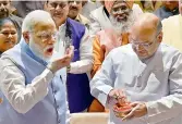  ?? — PTI ?? Prime Minister Narendra Modi eats Tirupati laddu
prasadam offered by BJP president Amit Shah during the BJP parliament­ary party meeting in New Delhi on Thursday.