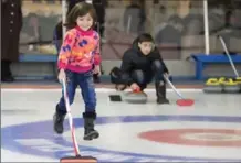  ?? FRANK GUNN, THE CANADIAN PRESS ?? A girl runs up the ice during Wednesday’s curling event for new arrivals to Canada at the Royal Canadian Curling Club in Toronto.