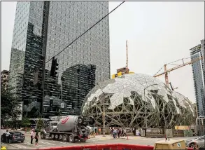  ?? The New York Times/STUART ISETT ?? Work continues around a set of geodesic domes recently built outside Amazon’s Seattle main headquarte­rs building earlier this month. Amazon, on the hunt for a place to build a second headquarte­rs, has sparked an enormous competitio­n among cities across...