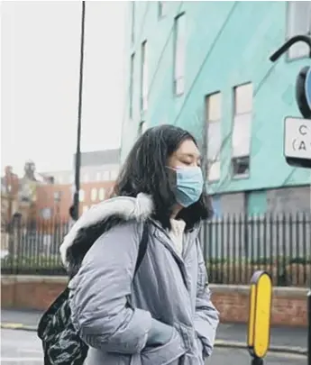  ??  ?? A woman wears a mask in Newcastle, where two coronaviru­s patients are bring treated in the RVI.