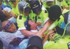  ??  ?? South Korean protesters grapple with policemen as they march toward the Blue House during a rally in Seoul yesterday against the deployment of the US Terminal High Altitude Area Defence missile intercepti­on system.