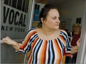  ?? BEBETO MATTHEWS — THE ASSOCIATED PRESS ?? Laura Levine looks out from the doorway of Vocal NY, an organizati­on that works with addicts where she is the health educator and coordinato­r for the opioid reversal drug Narcan, in the Brooklyn borough of New York. New York state is considerin­g providing medication­assisted treatment to all prison and jail inmates struggling with opioid addiction.