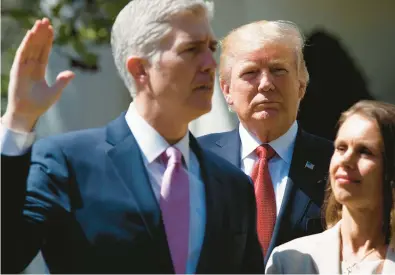  ?? EVAN VUCCI/AP 2017AP ?? Then-President Trump watches as Supreme Court Justice Neil Gorsuch, accompanie­d by wife Marie Louise, is sworn in.