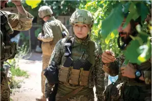  ?? The Associated Press ?? Ukrainian platoon commander Mariia talks to her soldiers in their position in the Donetsk region, Ukraine, on Saturday. Ukrainian soldiers returning from the frontlines in eastern Ukraine’s Donbas region describe life during what has turned into a grueling war of attrition as apocalypti­c. Mariia, 41, said that front-line conditions may vary depending on where a unit is positioned and how well supplied they are.