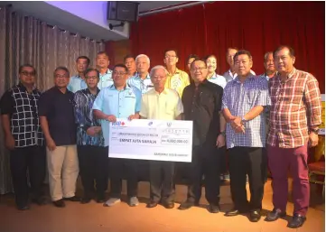  ??  ?? Masing (fourth right) presents a mock cheque for RM4 million to Temenggong Tan Kian Hoo, who received it on behalf of SJK(C) Ming Tat Relocation Fund. Also seen are Nanta (third right) and others.