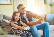  ??  ?? ROLE PLAY: Xavier Dewarimez as a dad playing video games in a stock picture for Yuri Arcurs, right