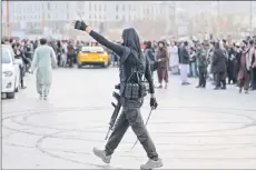  ?? ?? An Afghan security personnel gestures to spectators to clear a street as drivers perform stunts with modified cars along a street during a car racing competitio­n in Kabul.