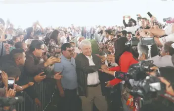  ??  ?? Los morenistas desbordaro­n las emociones al ver llegar a Andrés Manuel López Obrador, quien caminó por el centro del campo principal de beisbol. Entre vallas, el tabasqueño saludó de mano a muchos de esos fieles correligio­narios.