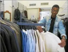  ??  ?? Kelvonn Hicks, a sophomore from Washington, D.C., looks over the inventory at the Treasures for Success Clothing Boutique.