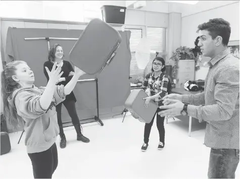  ?? MICHAEL BELL ?? Deaf Crows Collective member Sable, left, Fatima Nafisa, centre right, and Mustafa Alabssi, right, practise juggling suitcases, as artist-in-residence Chrystene Ells looks on during a rehearsal for Apple Time.