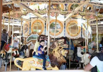  ?? Nancy J. Parisi ?? Children of all ages ride lions, ostriches and horses, of course, on the nearly 100-year-old carousel in Buffalo's Canalside.