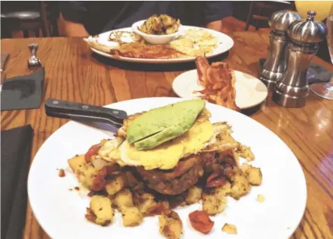  ?? STAFF PHOTO BY CHRIS ZELK ?? Steak & Eggs, foreground, from Bluewater Grille’s brunch menu features a 10-ounce, center-cut filet topped with two fried eggs and served with garlic cherry tomatoes, sliced avocado and brunch potatoes. In back are a la carte menu items Canadian bacon,...