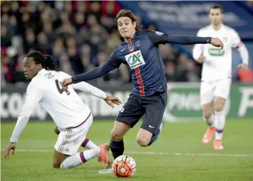  ?? — AFP ?? Paris Saint- Germain forward Edinson Cavani ( centre) vies for the ball with Bakary Kone of Lyon in their French Cup pre- quater- final at the Parc des Princes Stadium in Paris on Wednesday. PSG won 3- 0.