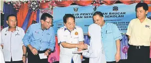  ??  ?? GUNA SEBAIKNYA: Wong (tiga kiri) menyampaik­an Baucar Pakaian Seragam Sekolah Yayasan Sarawak kepada salah seorang penerima.