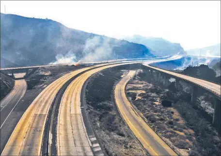  ?? Irfan Khan Los Angeles Times ?? PORTIONS OF THE 5 AND 14 freeways are closed Friday as Los Angeles County authoritie­s battle the Saddleridg­e fire in Porter Ranch.