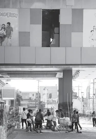  ?? BING GONZALES ?? WORKERS clean the broken glass in the premises of Gaisano Grand Mall in Digos City after the 6.3 magnitude earthquake jolted Tulunan, North Cotabato and neighborin­g areas on Wednesday evening.