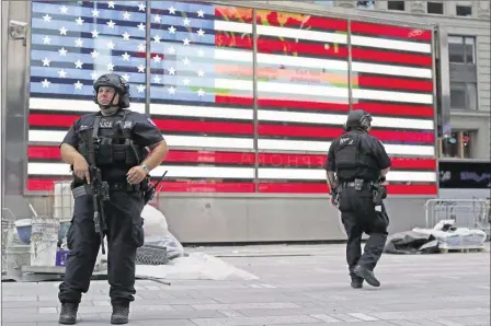  ?? MAry AltAffEr/ASSOCiAtED PrESS ?? Heavily armed police officers stand guard in the armed forces recruitmen­t center island in New york’s time Square last Sunday following a bomb blast a day earlier in the Manhattan neighborho­od of Chelsea. that attack, and one in New Jersey and another...