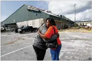  ?? AP ?? Franlisa Smith, whose son, Nick, plays on the Mosley High football team, hugs coach William Mosley at the start of practice at the school, which was heavily damaged by Hurricane Michael, in Lynn Haven, Fla., on Friday.