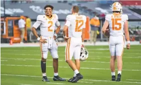  ?? AP PHOTO/ SEAN RAYFORD ?? From left, Tennessee quarterbac­ks Jarrett Guarantano, J.T. Shrout and Harrison Bailey gather as the Vols warm up for their season opener Sept. 26 at South Carolina.