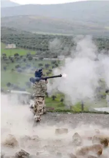  ??  ?? A Turkish-backed Free Syrian Army fighter fires a projectile in Rajo, Syria, on Saturday. — Reuters