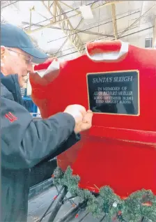  ?? SUBMITTED PHOTO ?? David White of the New Glasgow Fire Department attaches a plaque to Santa’s sleigh in honour of Alvin Richard Mueller, who requested to see Santa and a fire truck in 2004. Since this time, the fire department has been making its annual Christmas Eve...