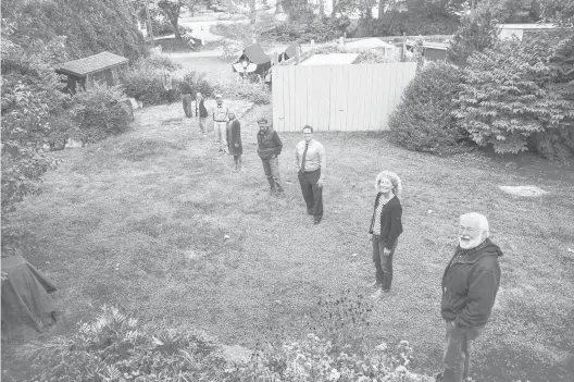  ?? MARK MIRKO PHOTOS/HARTFORD COURANT ?? Town of Groton officials and members of Groton’s Resilience and Sustainabi­lity Task Force, led by Zell Steever, front, fan across Steever’s backyard in a demonstrat­ion of the increased threat of flooding due to climate change. In the event of a 100-year storm, water would reach the edge of Steever’s property, and in the event of a 500-year storm, it would flood up to where he stands, according to Federal Emergency Management Agency projection­s.