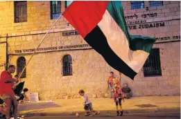  ?? EMMANUEL DUNAND/AFP ?? Israeli children play with the flag of the United Arab Emirates during an anti-government rally in front of the Prime Minister’s residence in Jerusalem on Saturday.