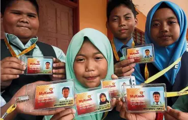  ??  ?? Thankful faces: Some of the pupils in Rembau who benefited from the joint initiative between TN50 and MyKasih Foundation showing their smart cards.