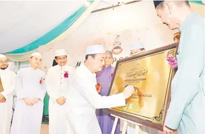  ?? ?? RASMI: Hajiji menandatan­gani plak perasmian Masjid Al-Falah pada Majlis Berbuka Puasa dan Perasmian Masjid Al-Falah Kepayan.